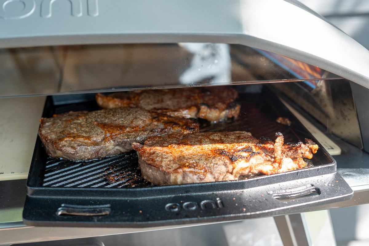 ribeye steaks cooking in Koda 2 Max pizza oven