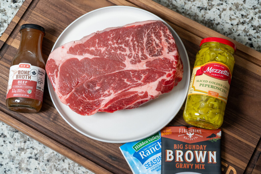 ingredients for mississippi pot roast laid out on a wooden board