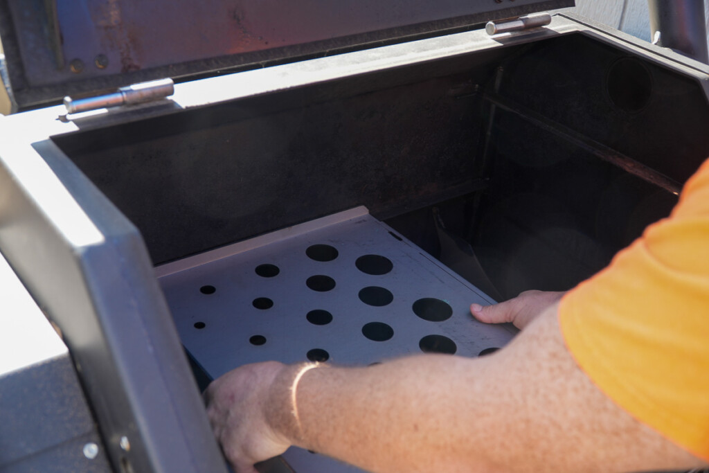 two hands placing the difuser into the smoker