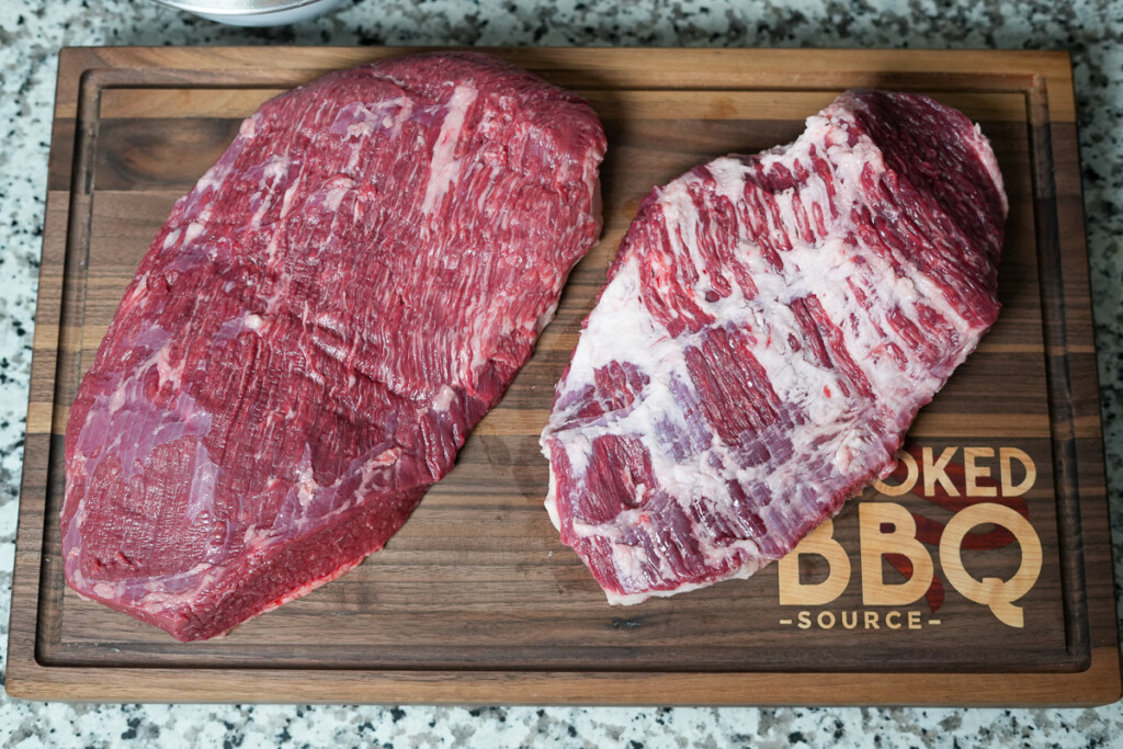 the flat and point of brisket, raw on a wooden chopping board