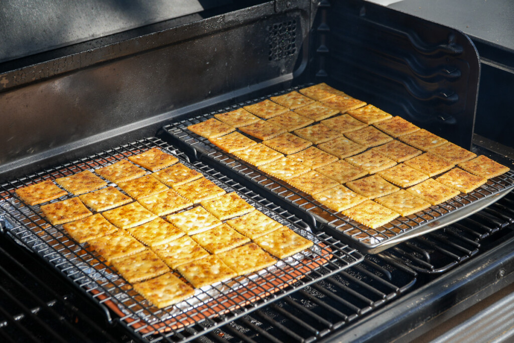 two wire racks with crackers on in the smoker