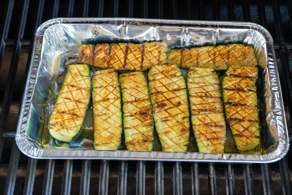 cooked zucchini in aluminum tray with a butter braise