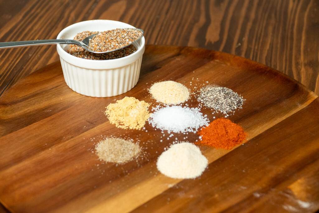 the ingredients for smoked chicken rub laid out on wooden board