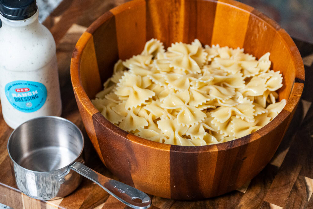 a large wooden bowl full of cooked farfalle pasta