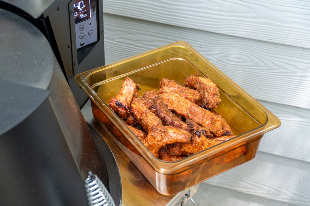 cooked party ribs in an H-cambro sitting on the side of a grilla grills