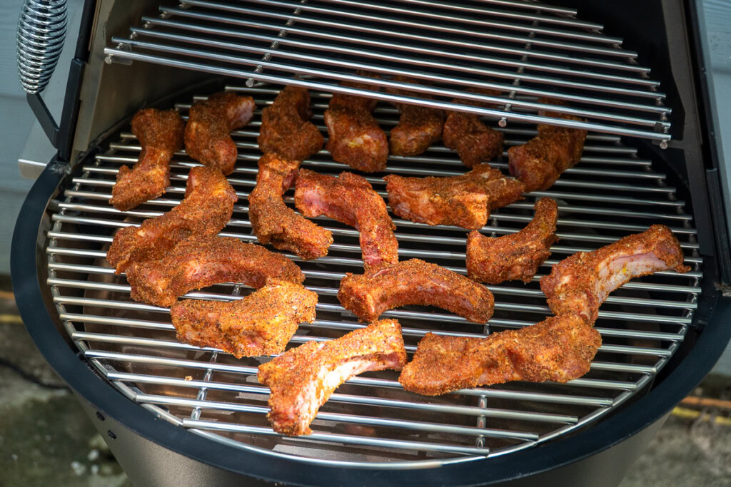 raw seasoned party ribs on the smoker