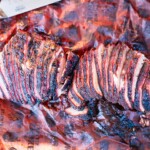 Sliced smoked tri-tip brisket-style on butcher paper showing bark and smoke ring.