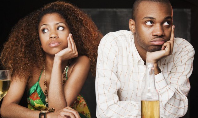 Couple sitting at bar and looking irritated