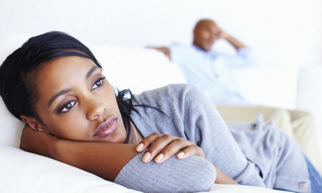Unhappy woman lying in couch