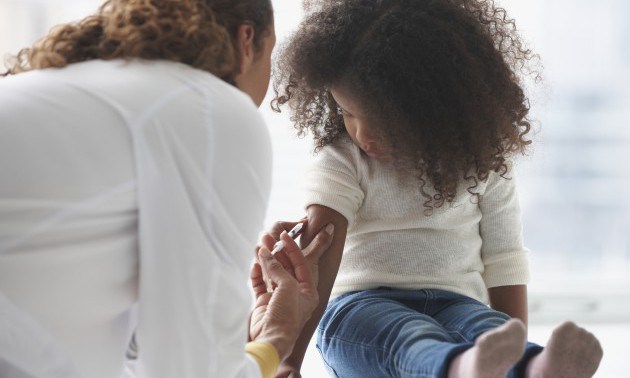 Doctor vaccinating girl in office