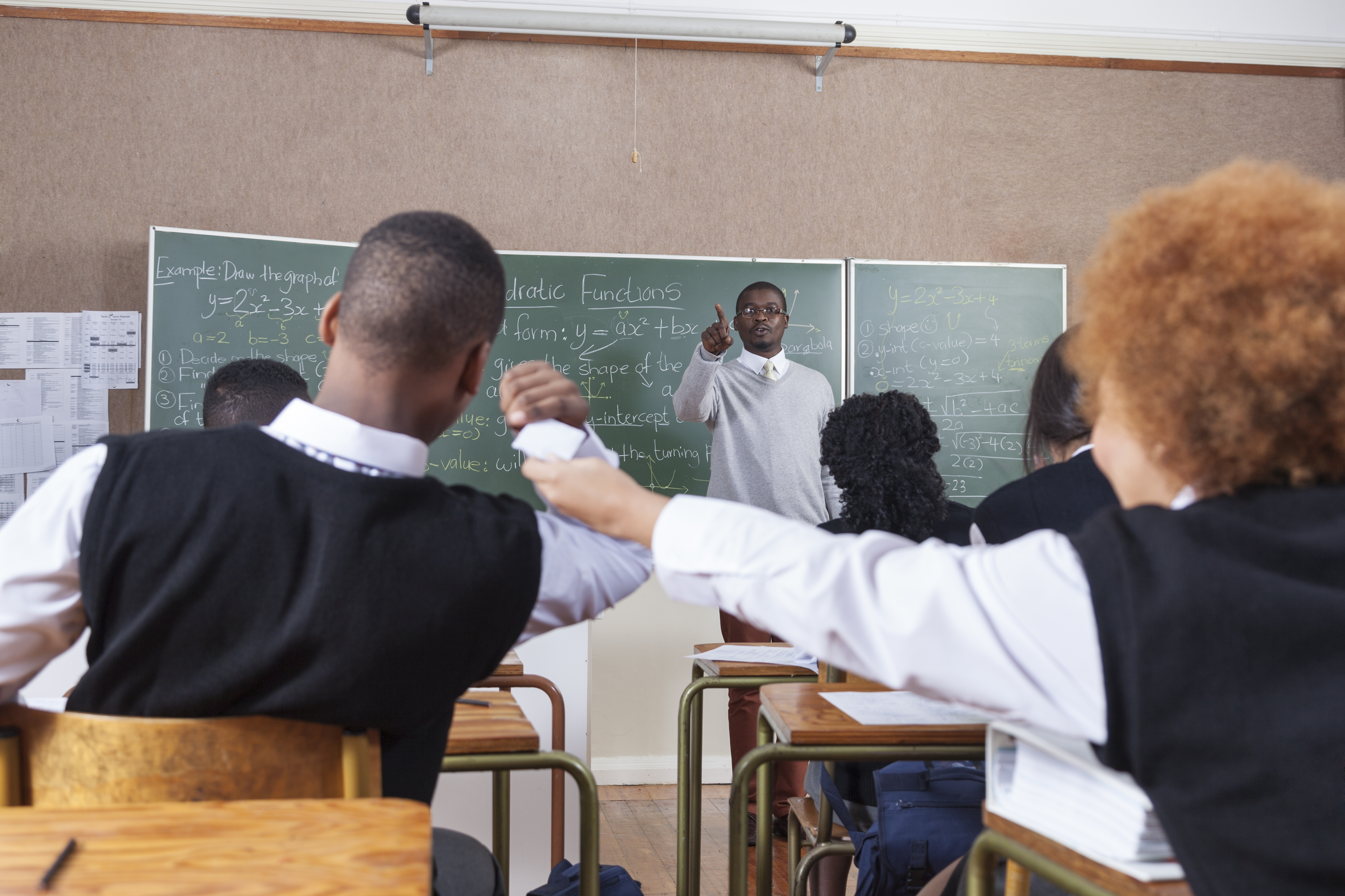 A teacher scolding students for passing notes in the classroom, Cape Town, South Africa