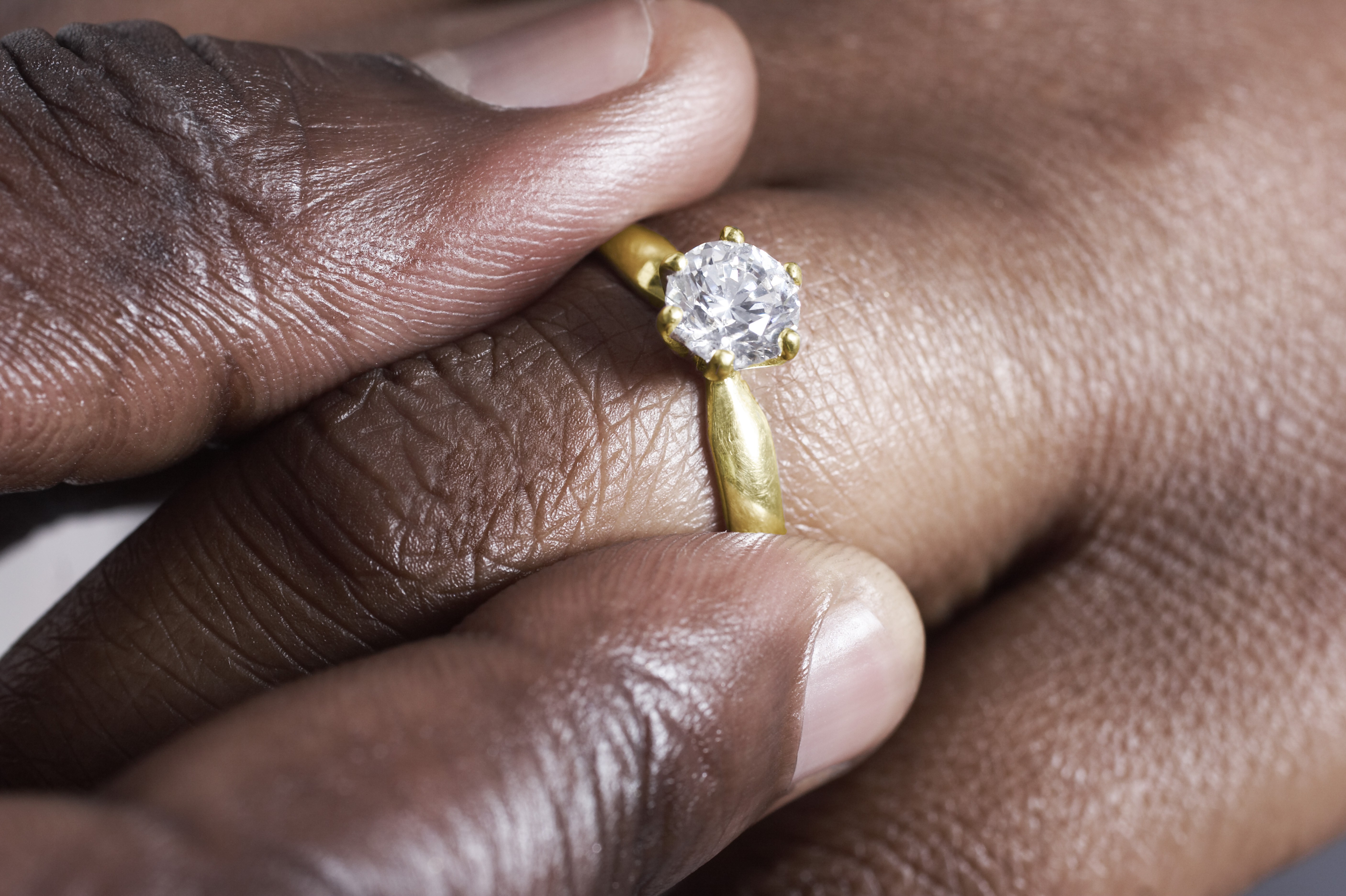 Man putting wedding ring on woman.