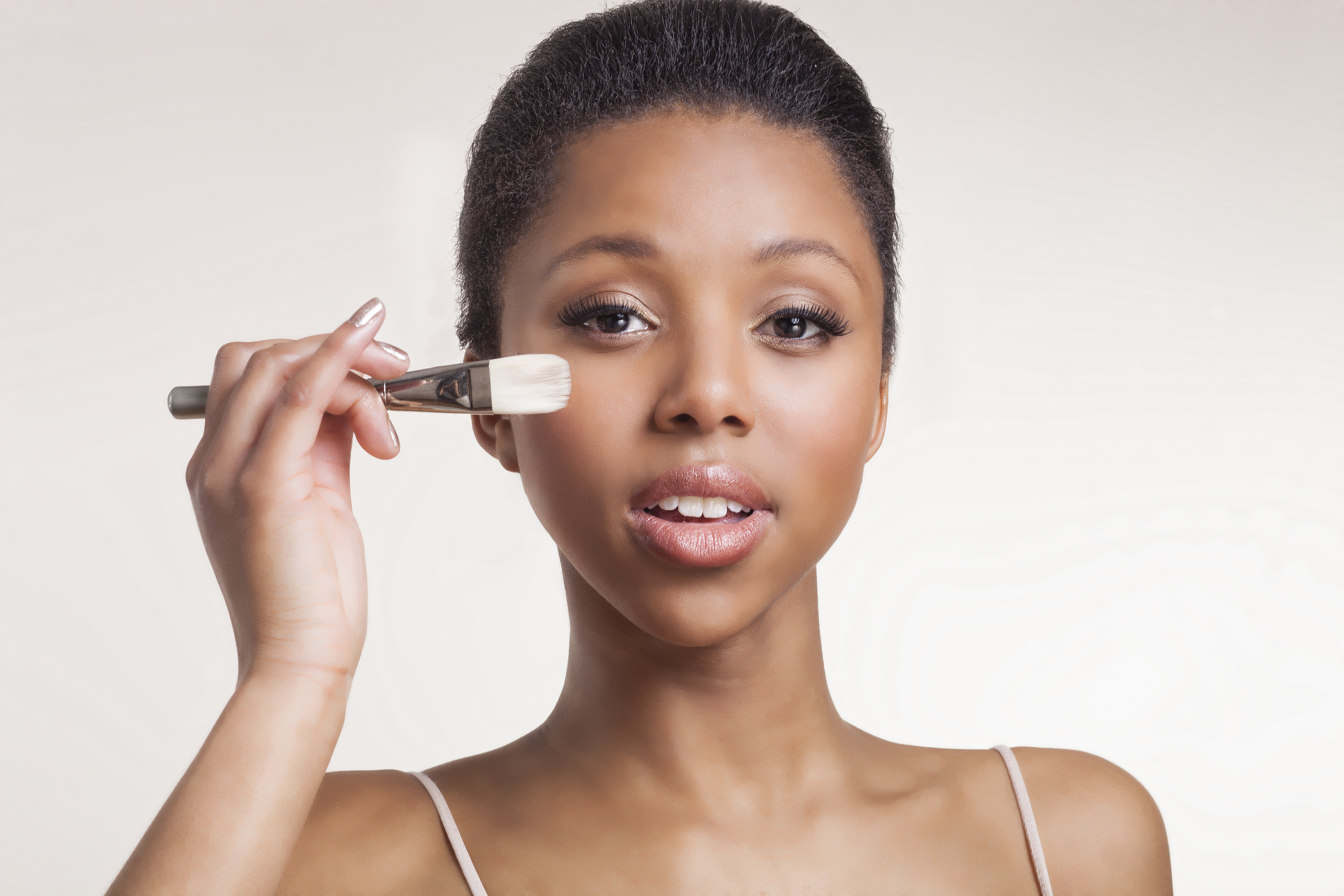 lady holding foundation brush near her cheek