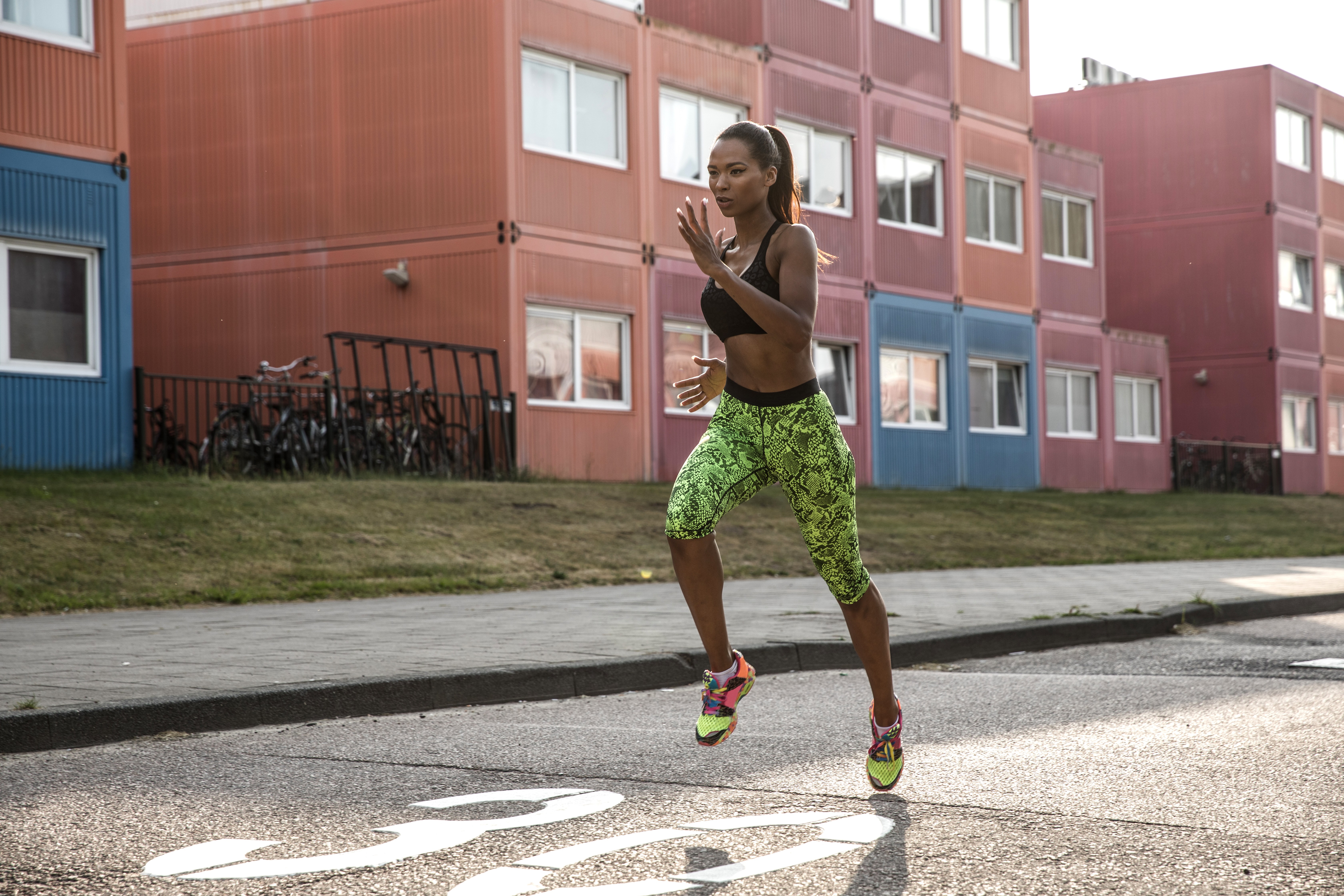 Fit woman exercising in city industrial district in Amsterdam - determination and strength lead to success