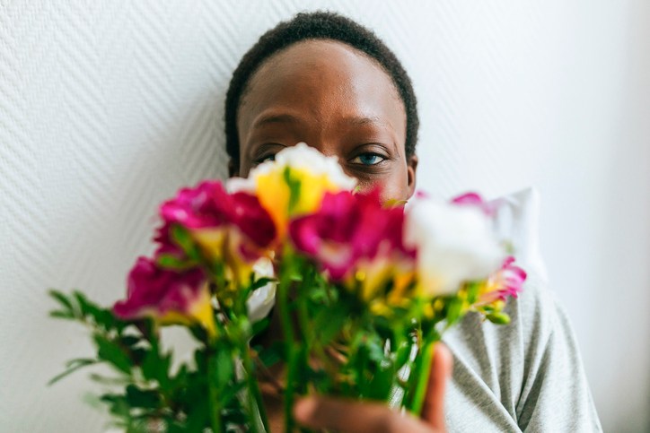 Portrait of woman behind flowers