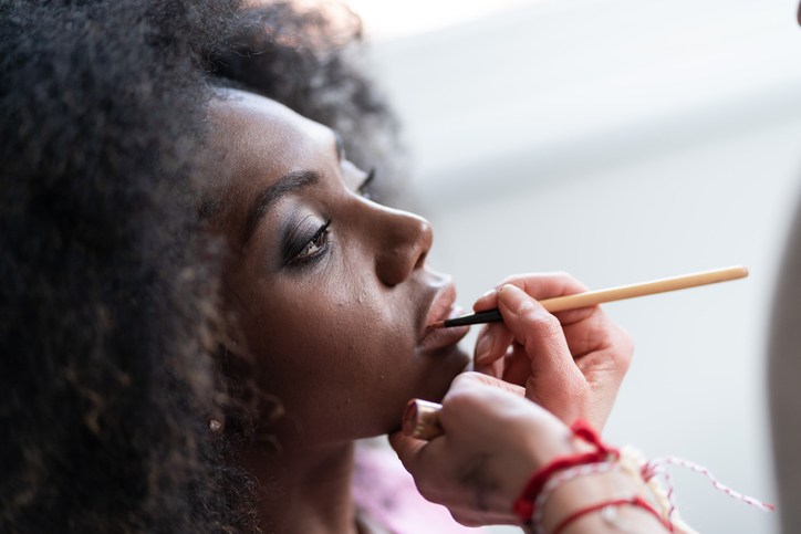 Makeup artist applies lipstick