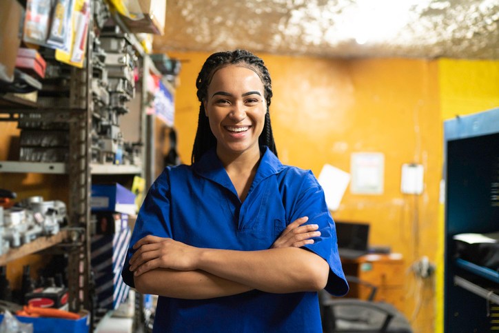 Portrait of a female mechanic with arms crossed in a auto repair shop