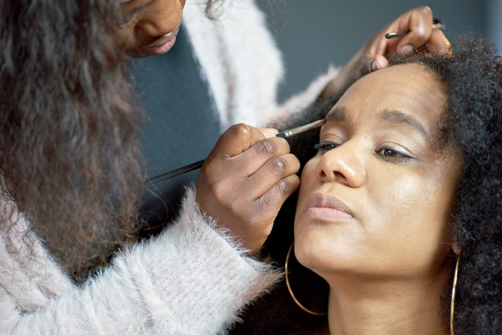 A make-up artist applying make-up to the face of her client