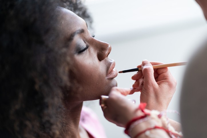 Makeup artist applies lipstick
