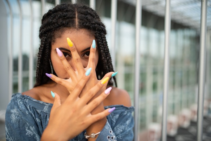 Woman covering face with hand and staring at you