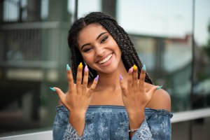 Cheerful fashion girl posing with multicolored nails