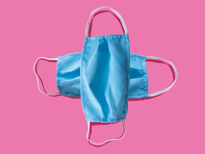 Blue medical face mask to avoid contagious diseases pattern on pink background