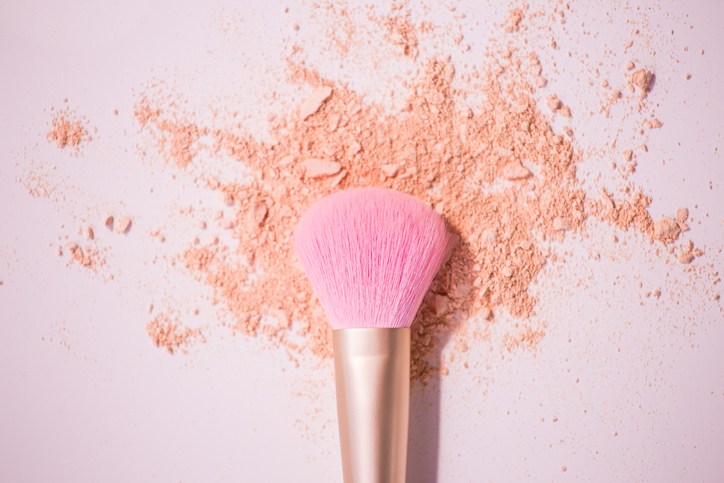 Make up brushes with powder on white background