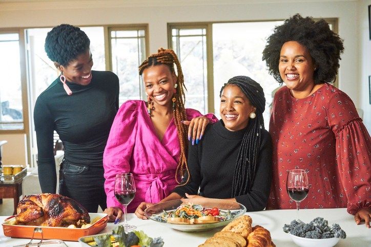 Happy friends having fun at dining table in party