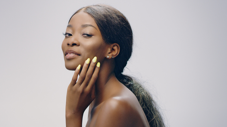 Dreamy african ethnicity woman face skin care. Smoothing skin