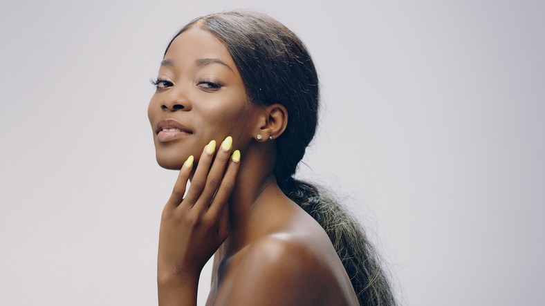 Dreamy african ethnicity woman face skin care. Smoothing skin