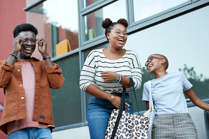 Cheerful young friends against window at college