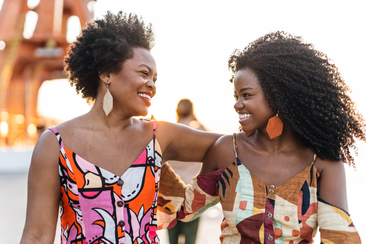 Smiling women in the city at sunset
