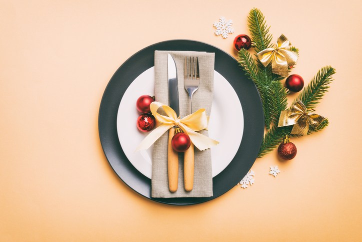 Christmas table place setting with christmas decor and plates, kine, fork and spoon. Christmas holiday background. Top view