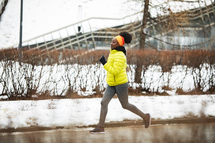 Young African woman training outdoors in bad weather
