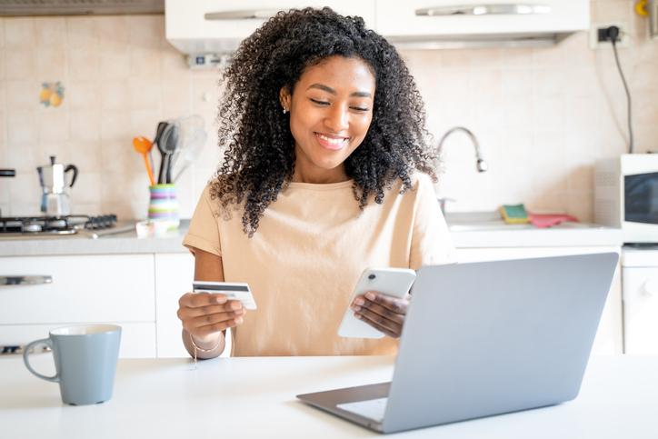One happy black woman making credit card purchase from home
