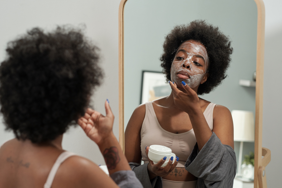 A woman applying face cream
