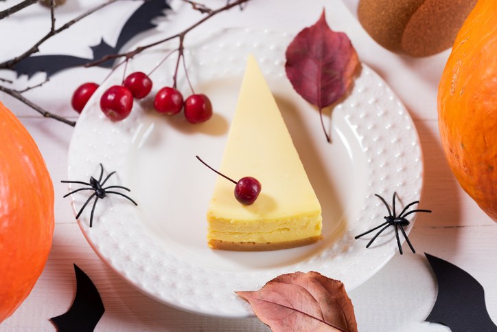 Halloween party table setting design with pumpkin pie, pumpkins, black spiders, owls, dry twigs.