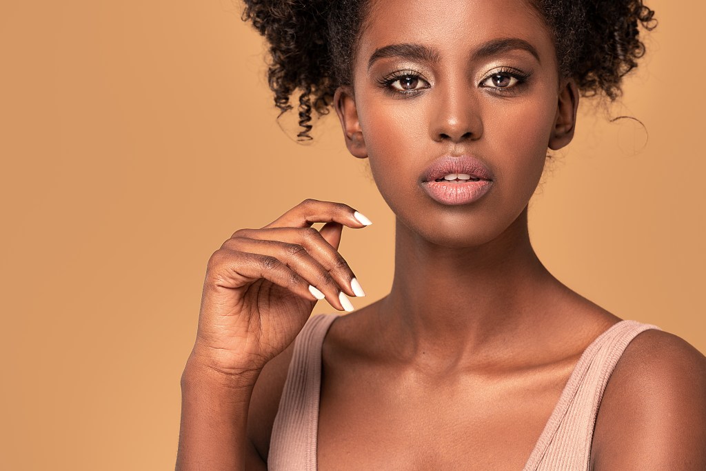 A Black woman with a white manicure