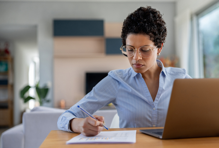 Business woman working on her laptop at her home office