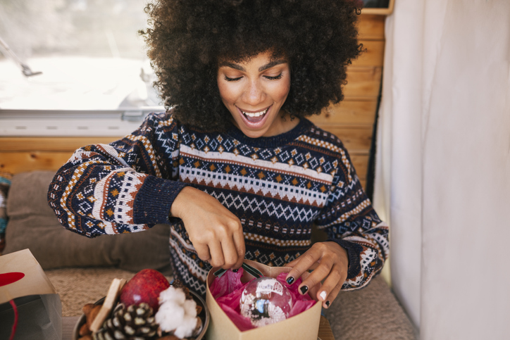 Girl excitedly opening a Christmas present in her van