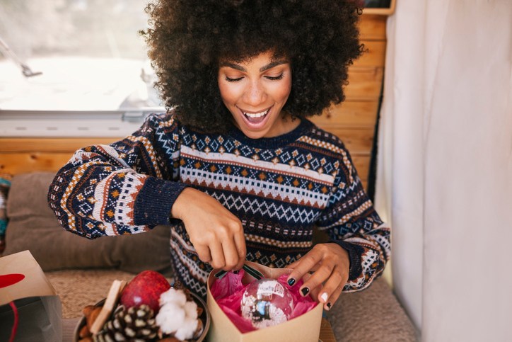 Girl excitedly opening a Christmas present in her van