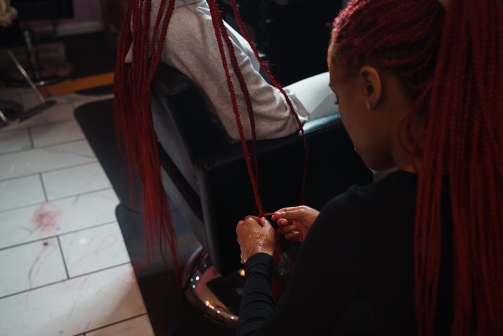 Stylist Braiding Hair in a Salon