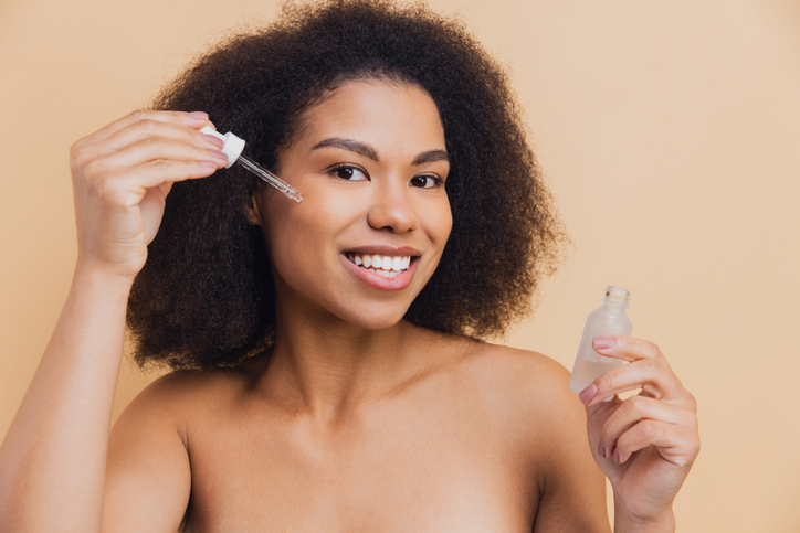African American woman applying serum for skincare routine