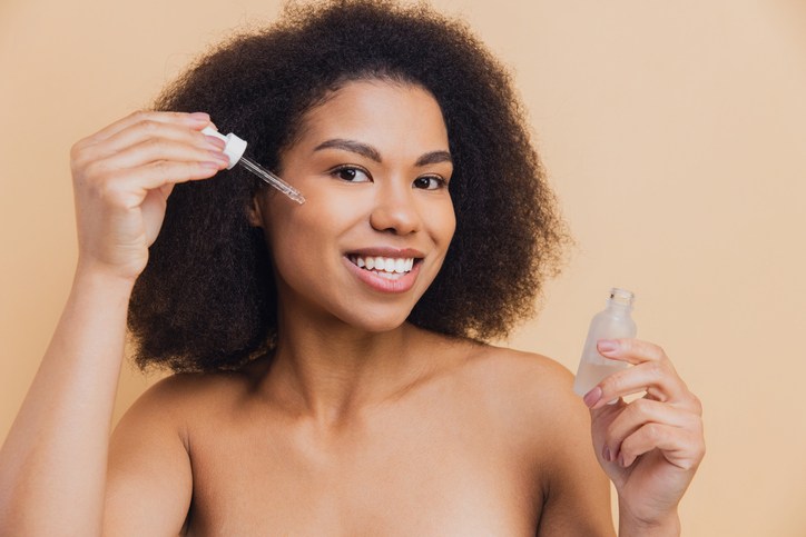 African American woman applying serum for skincare routine | Best Body Oil Products