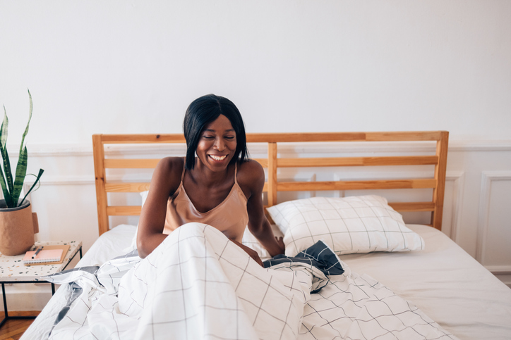Rise and Shine! Beautiful Smiling African American Woman Slowly Getting out of Bed in the Morning