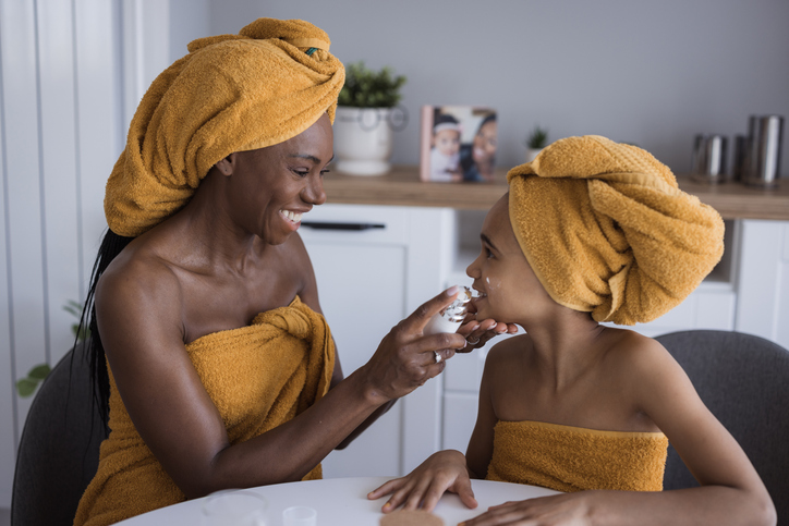 Woman puts cream on her teenage daughter