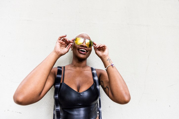 Fashionable female wearing aviator sunglasses on urban sidewalk