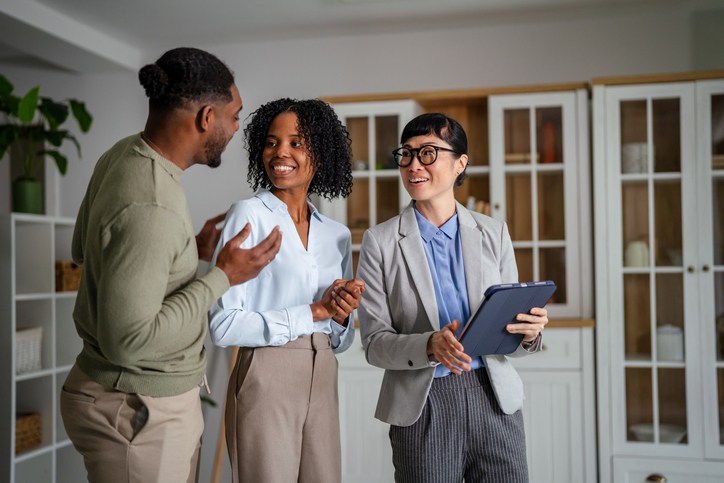 Real estate agent showing new home to happy couple