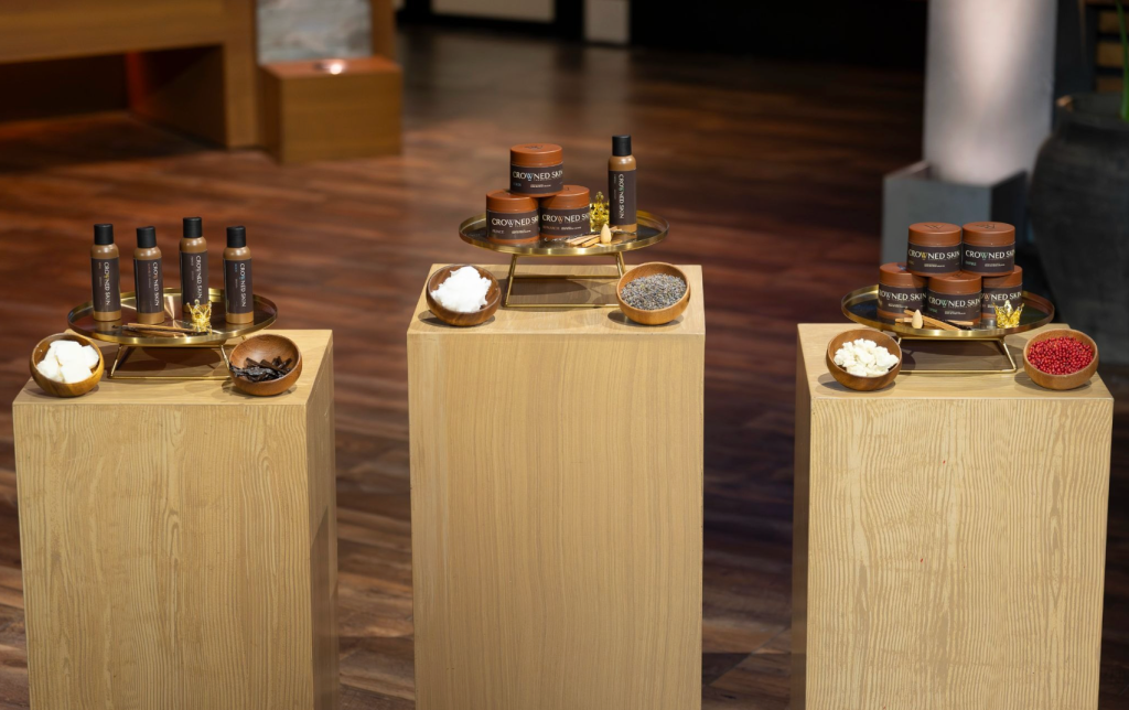 Wooden display stands with various Crown Spa products, including oils, salts, and other spa items.