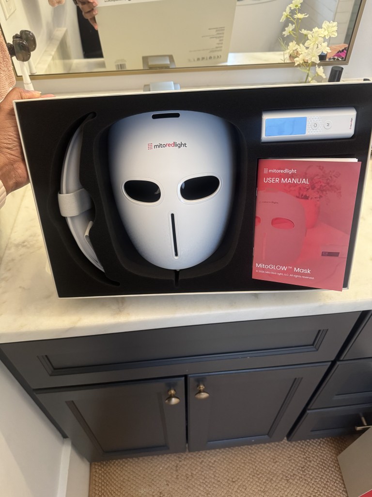 A white medical face mask with the Mitored light logo and the MitoGLOW Mask product name displayed on a black background.